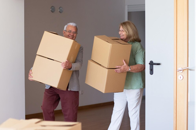 Two people holding boxes packing and organizing